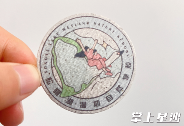 “种子徽章”正面印有松雅湖湿地自然学校logo，其内部布满了星星点点的小种子。王俊 摄