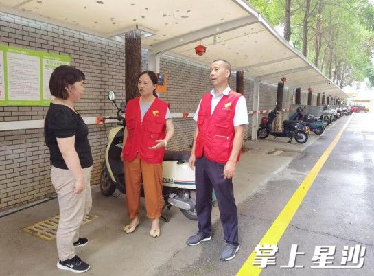 向星社区工作人员在小区引导居民将电动车停至新建的电动车棚内。泉塘街道供图