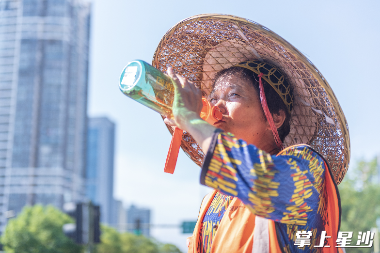 负责凉塘路卫生清洁的环卫工人大口饮水。刘思源 摄