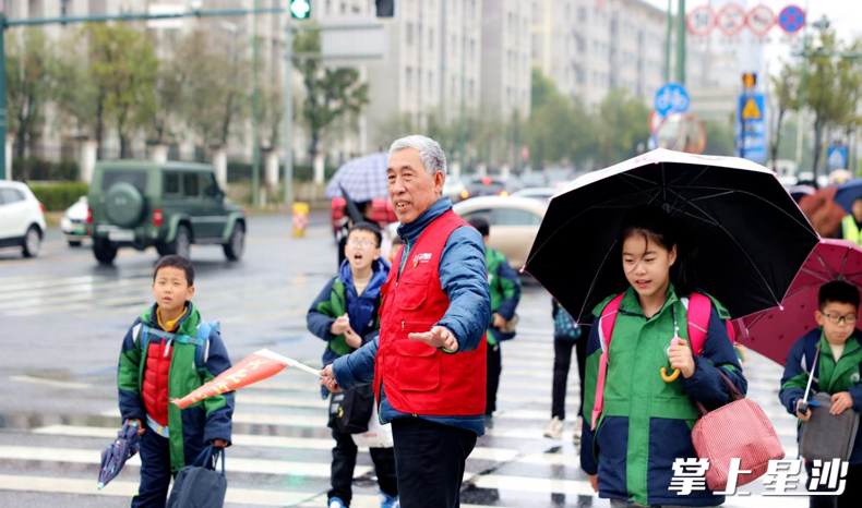 “湖南好人”陈小明在长沙县百煕实验学校门口护学。长沙县文明办供图