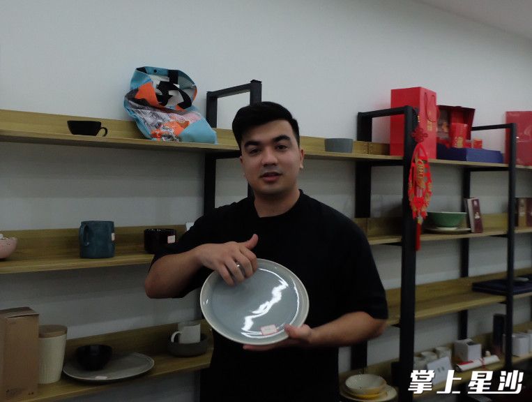 马逸贤在给记者介绍他推介的中国陶瓷。