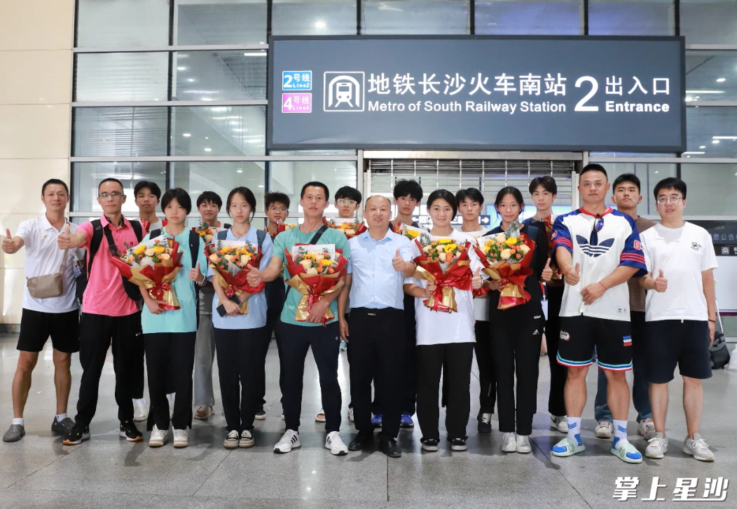 长沙县一中学领导到高铁南站，用鲜花迎接校田径队凯旋而归。学校供图