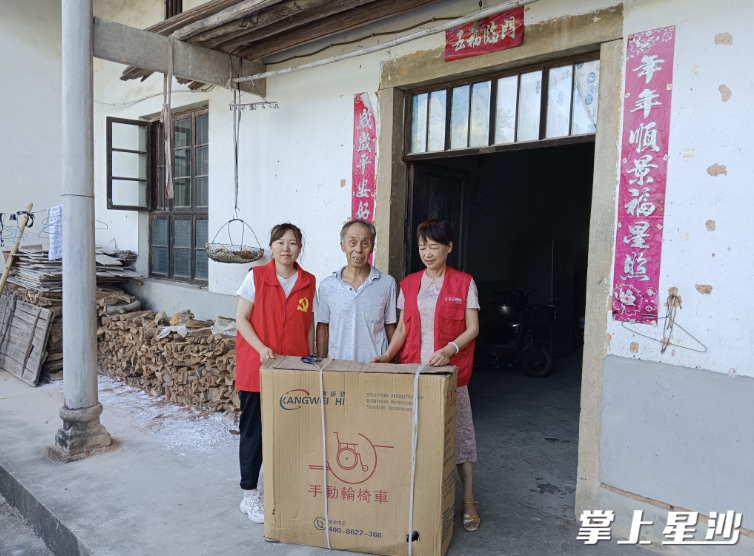 给黄爹捐赠轮椅（左1黄娟，右1范伟红）。福临镇供图