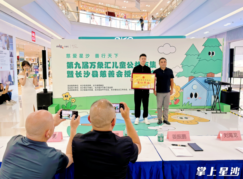 长沙县民政局慈善事业促进科负责人向长沙星沙万象汇负责人授予爱心单位牌匾。