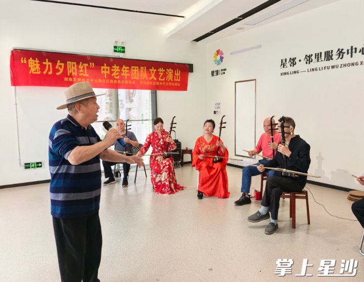 老人们在邻里服务中心参与器乐合奏。