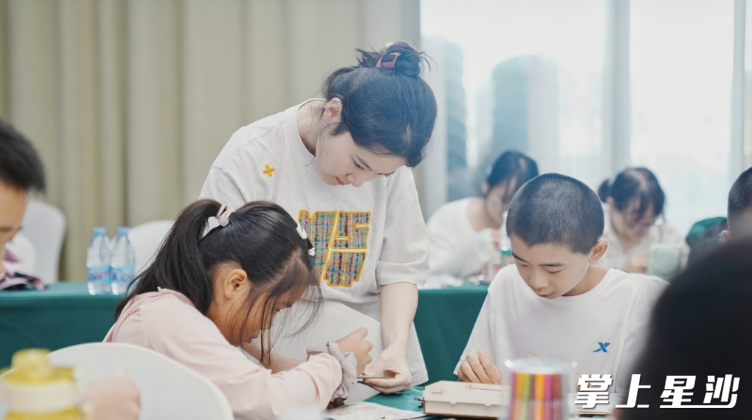 研学导师指导孩子们制作红色小木箱。