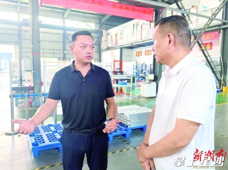 泉塘街道党工委负责人（左一）组织相关部门在湖南港鑫精密科技有限公司走访。