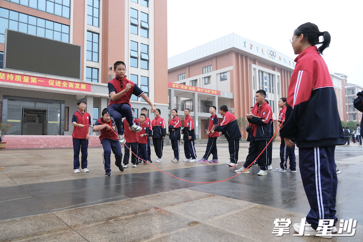 春华中学校园内，孩子们在课间组织团体跳绳活动。