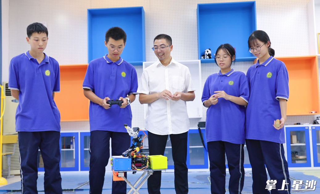 长沙县第一中学数学老师段贤清和学生一起制作机器人。李杰 摄