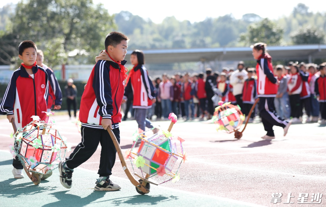在金井镇双江小学操场，伴随着欢快的音乐，七八个学生各自推着滚灯车，摆出各种队形，博得围观的学生阵阵喝彩。课间玩转“非遗”，已成为学校课间一道靓丽风景。李杰 摄