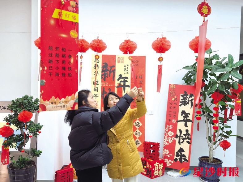 　　在星沙街道杨梅冲社区，居民们相互讨论、竞相猜解灯谜。星沙街道供图
