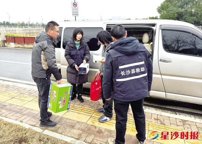 　　长沙县救助站工作人员为流浪人员送上节日及生活物资。柳峥 摄