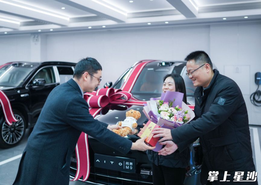 在AITO问界·长沙中南用户中心交车区客户络绎不绝，工作人员为来自益阳的客户何先生夫妻送上鲜花和巧克力，甜蜜值拉满。2025年，该门店累计交付车辆260+台，销售额突破亿元大关。