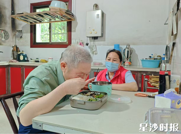 从一餐热饭出发，青山铺镇用精细化服务破解农村养老难题。图为志愿者为留守老人送餐。杨源 摄