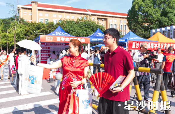 长沙县实验中学考点，考生家长身着旗袍与考生合影，祝愿孩子考上心仪大学。刘思源 摄
