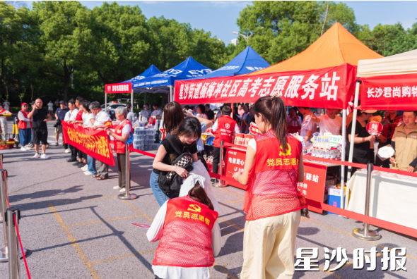 长沙县实验中学考点，党员志愿者帮考生捡拾掉落物品。刘思源 摄