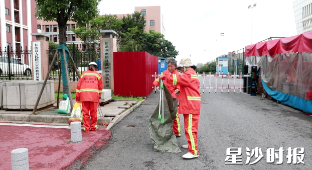 考试期间内，各考点周边改由人工保洁方式进行清扫。谭园 摄