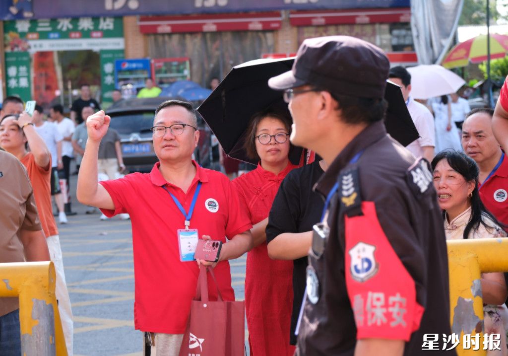 在长沙市明达高级中学考点，老师们穿上“旗开得胜”文化衫为考生加油。