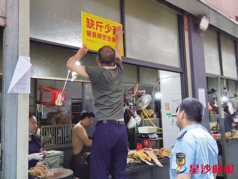 　　▼执法人员对缺斤少两商户“黄牌警告”。