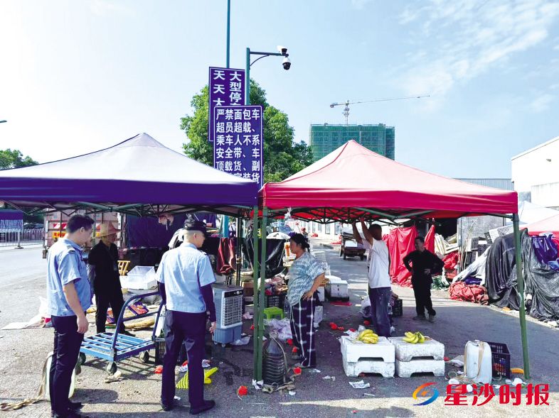 　　在黄兴镇海吉星出入口周边，执法人员正在和摊主沟通。　　黄兴镇供图