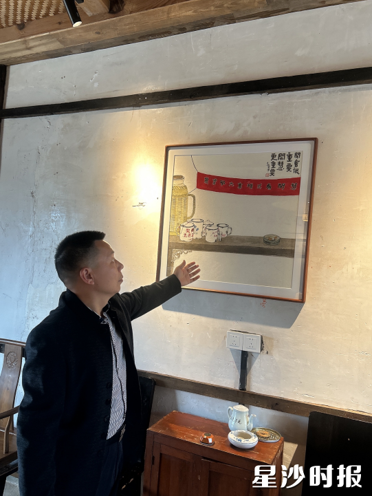 图为作者在包厢看到漫画上的文案“开会很重要，开慧更重要”。