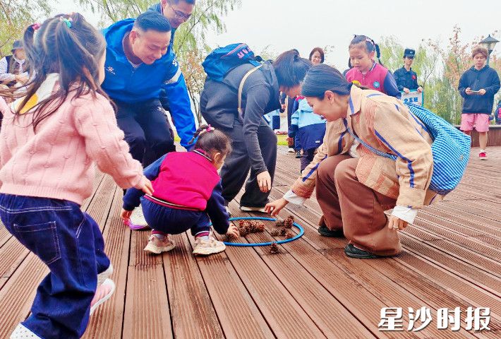 图为幼儿园进行小松鼠运松果游戏。
