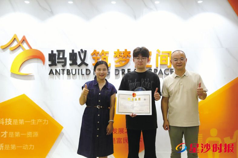 　　湖南灵岭科技有限责任公司创始人查子涵（中）拿到营业执照。黄兴镇供图