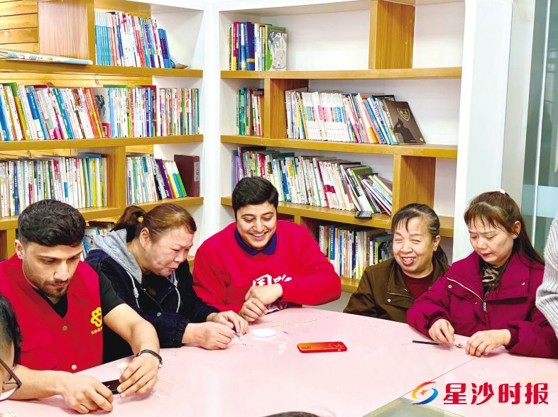 在高峰社区党群服务中心,留学生们和社区非遗老师们共同制作非遗螺钿手工。赵佳慧 摄
