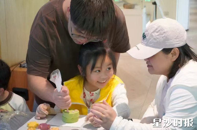 亲子家庭携手制作爱心宠物蛋糕。