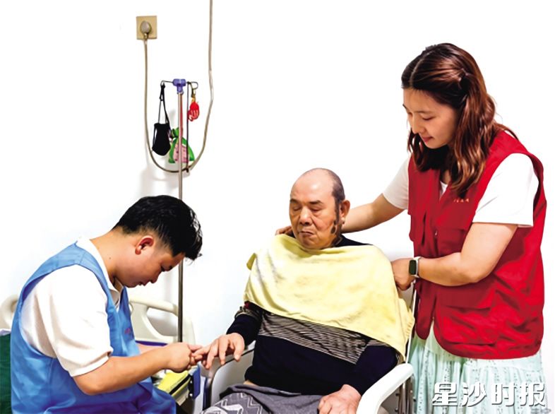 助老护理员谢启禄(左)、社工吴露益(右)为王令可老人修剪指甲。 助老护理员谢启禄(左)、社工吴露益(右)为王令可老人修剪指甲。