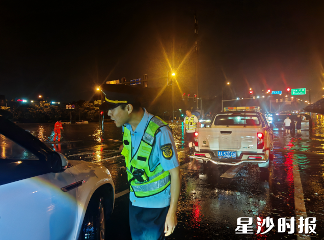 执法人员在积水区设置临时警戒，劝导过往车辆绕行避险。县行政执法局供图