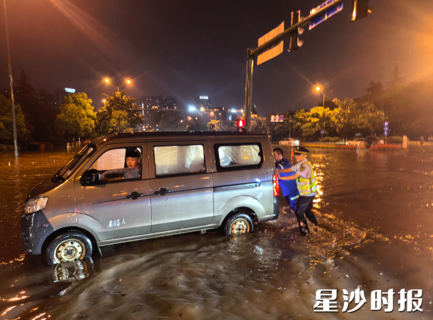 执法人员紧急救助雨中抛锚车辆。县行政执法局供图