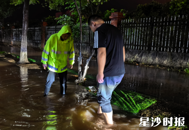 长龙街道组织工作人员冒雨清理堵塞物，确保雨水箅子通畅。长龙街道供图