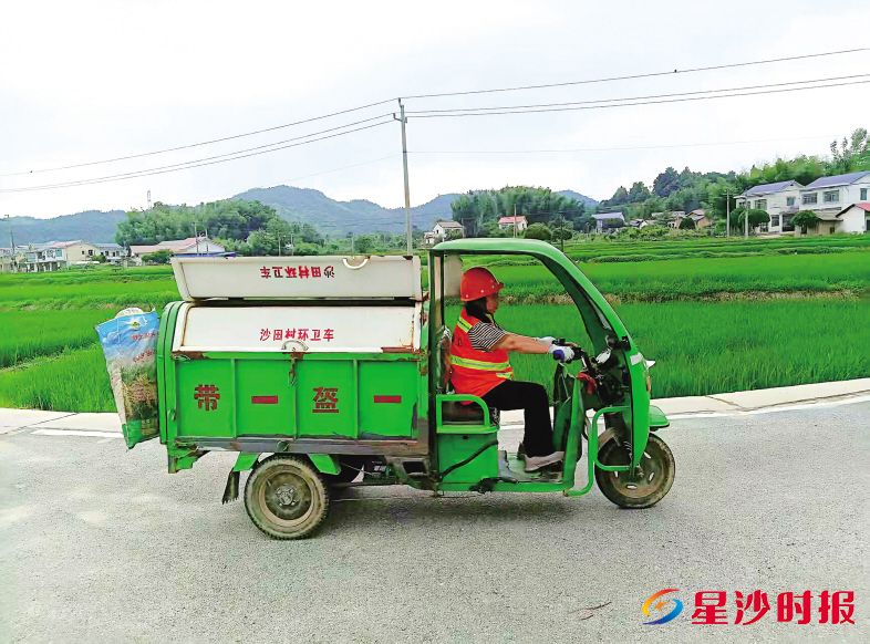 保洁员易小平熟练地戴上智能工牌,骑上装有GPS的环卫三轮车开始工作。通讯员供图