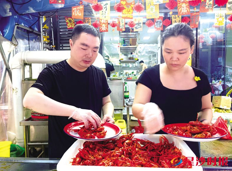 图为贺敏、成慧夫妇在门店忙碌。 县文明办供图