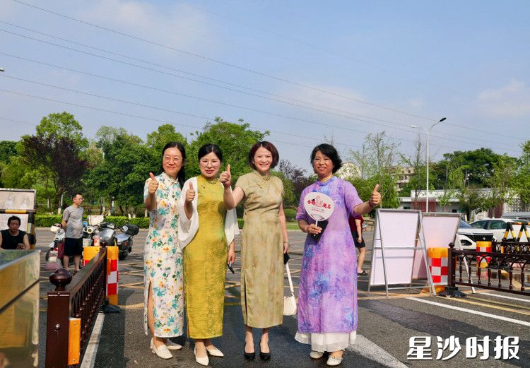 长沙县第一中学考点外，妈妈们穿上旗袍，寓意 “旗开得胜”，为考生加油。文雅丽 摄