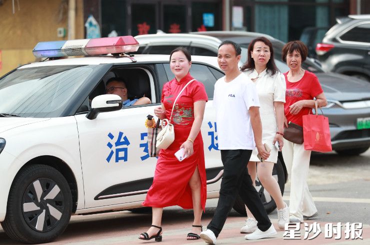 在黄兴镇长沙市明达中学考点，家长们身穿旗袍，满怀期待等着孩子们走出考场。李杰 摄