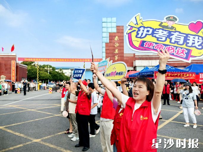 在长沙县一中考点，退役女兵何来美为考生加油助力。陈茂 摄