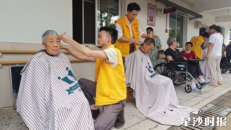 爱心义剪专区的理发师为老人理发。