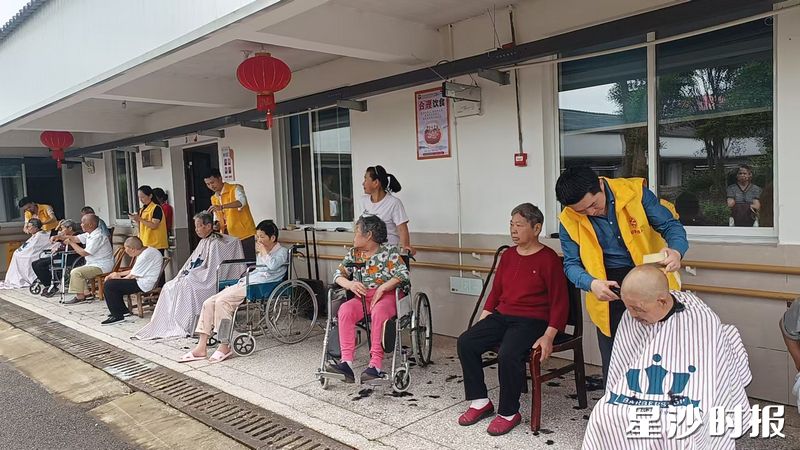 理发师为老人义务理发。