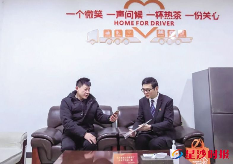 晟象智慧物流园党总支书记黄林叶(右)引导司机扫码。资料图片