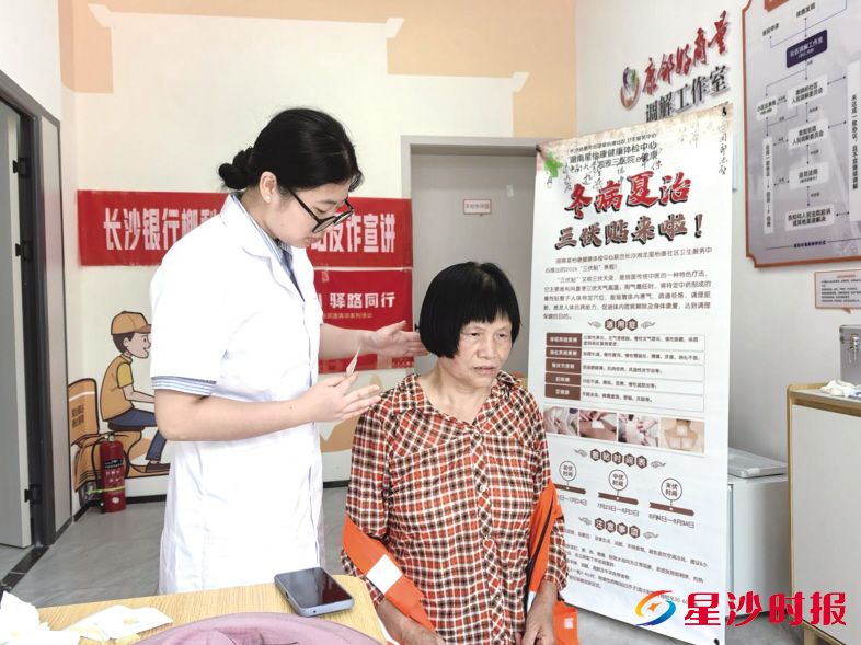 环卫工人在康狮岭社区“狮岭驿家”爱心驿站贴三伏贴。㮾梨街道康狮岭社区供图