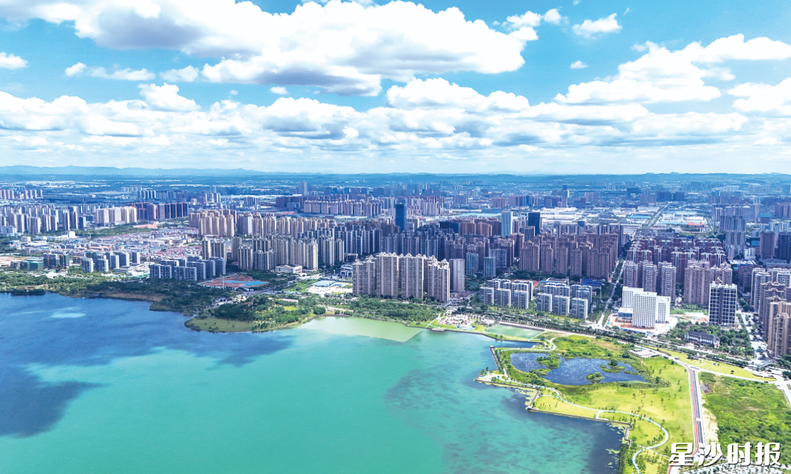 碧波荡漾的松雅湖畔,城市高楼林立。章帝 摄