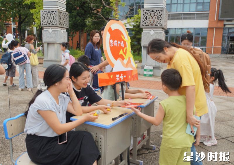 在长沙市自贸实验学校,师生与家长温情互动,孩子接过任务卡片,在游戏体验中迎接新学期。